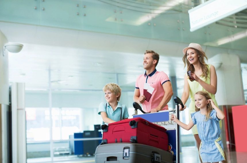 A family is standing in an airport with luggage.